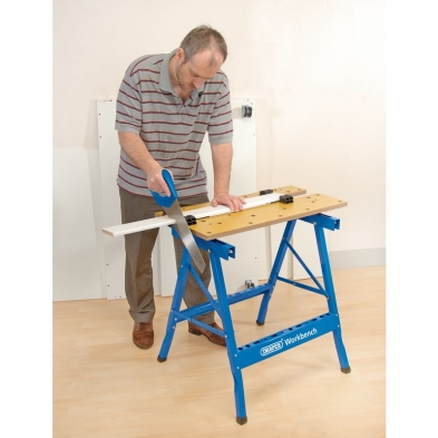Carpintero usando el banco de trabajo Draper como mesa de sujeción en taller