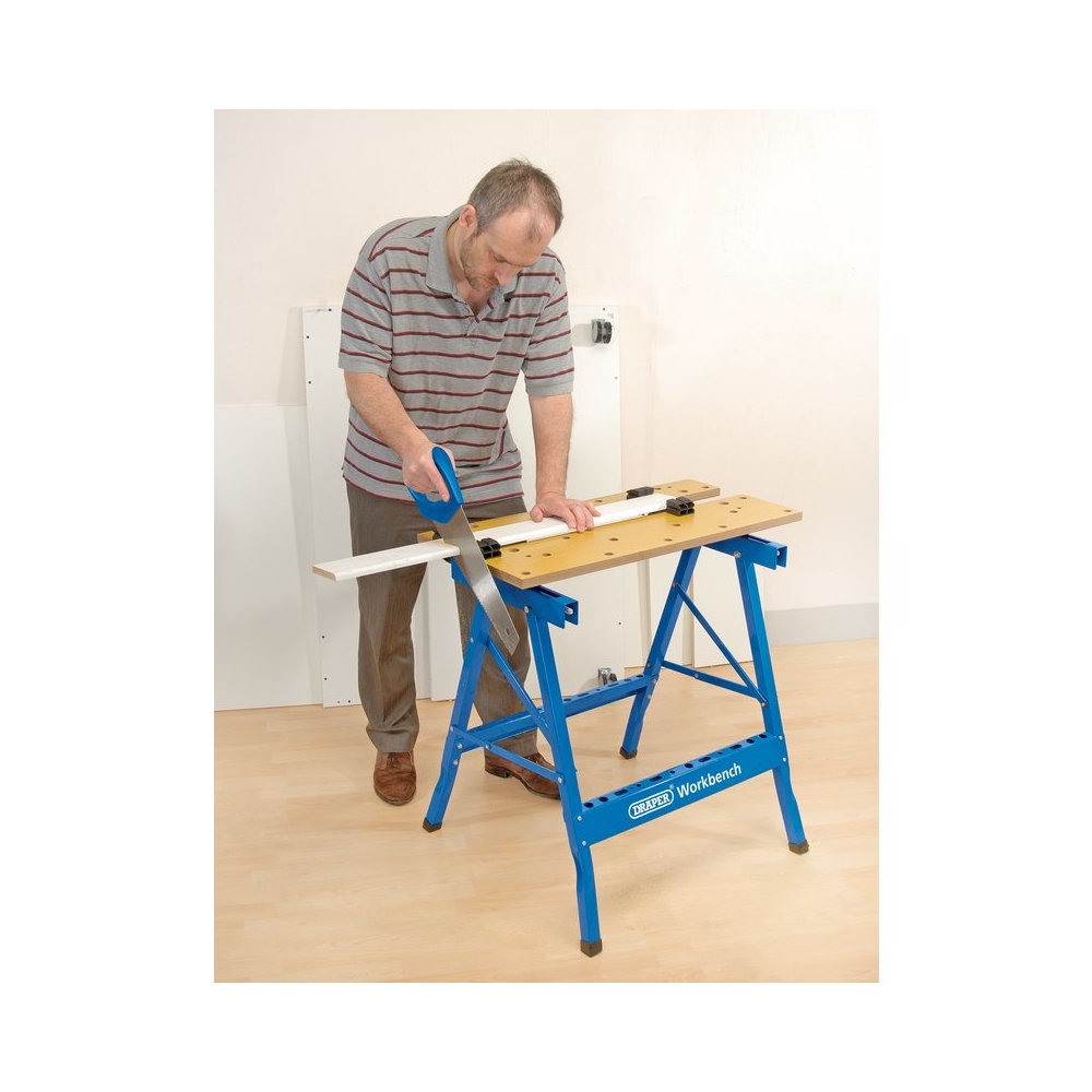 Carpintero usando el banco de trabajo Draper como mesa de sujeción en taller