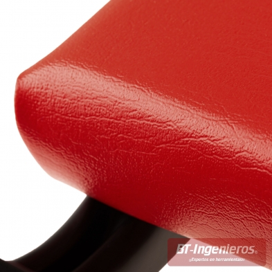 Primer plano del tapizado acolchado en vinilo rojo de la camilla Piramide.