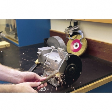 Esmeriladora Draper de banco con sistema húmedo y seco en uso sobre metal.