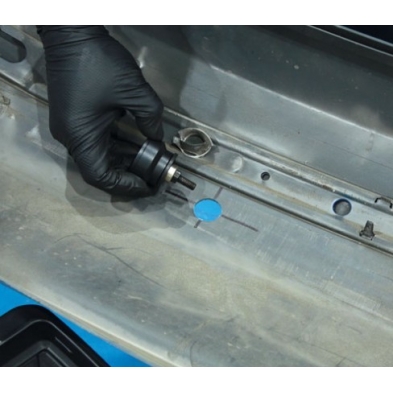 Fresa instalada en parachoques para perforar orificio de sensor de aparcamiento.