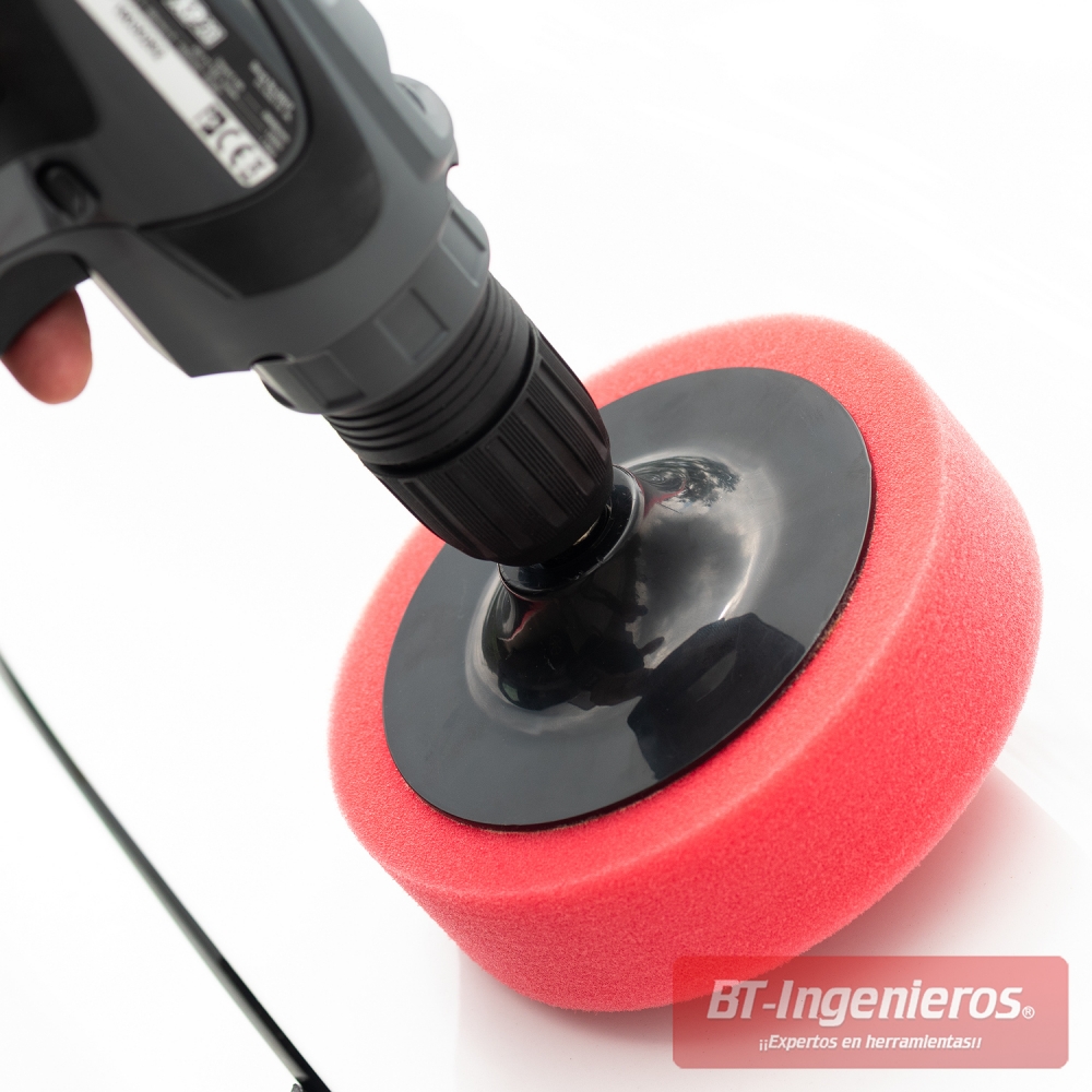 Detalle de aplicación de esponja roja sobre superficie blanca en proceso de pulido