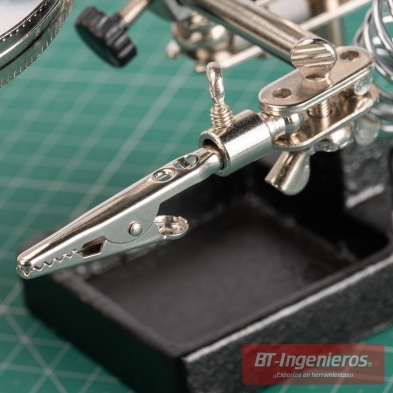 Detalle de pinza cocodrilo ajustable en una tercera mano con tornillo de fijación y bandeja inferior